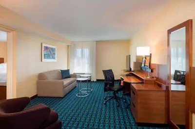 a hotel room with a couch and a desk at Fairfield Inn & Suites by Marriott Paramus in Paramus