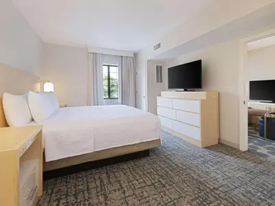 a hotel room with a bed and a flat screen tv at Homewood Suites by Hilton Parsippany-Troy Hills in Parsippany