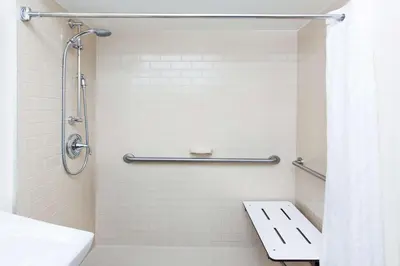 a bathroom with a shower with a toilet and a sink at Sonesta Simply Suites Parsippany Morris Plains in Morris Plains