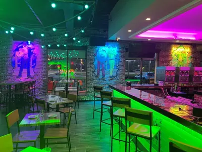 a restaurant with a bar with neon lights at Holiday Inn & Suites Parsippany Fairfield by IHG in Parsippany