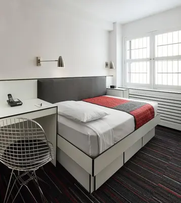 a bedroom with a bed with a desk and a chair at Pod 51 in New York