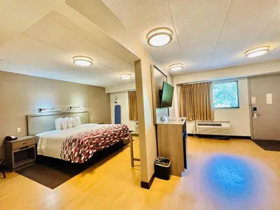 a large hotel room with a bed and a television at Red Roof Inn Milford - New Haven in Milford