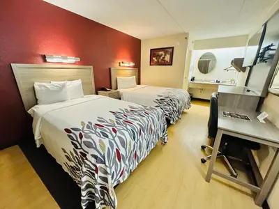 a hotel room with two beds and a desk at Red Roof Inn Milford - New Haven in Milford