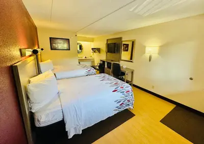 a hotel room with two beds and a desk at Red Roof Inn Milford - New Haven in Milford
