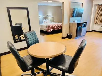 a room with a table and chairs and a bed at Red Roof Inn Milford - New Haven in Milford