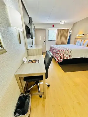 a hotel room with a bed and a desk and a bed and a room at Red Roof Inn Milford - New Haven in Milford