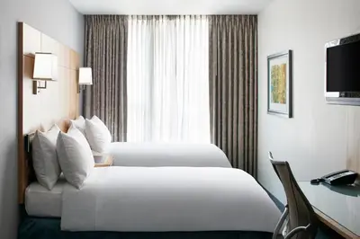 a hotel room with two beds and a desk at Club Quarters Hotel World Trade Center, New York in New York