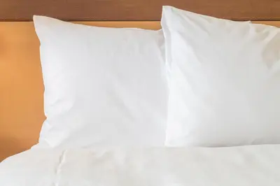 a bed with white sheets and pillows on it at Holiday Inn Express Great Barrington by IHG in Great Barrington