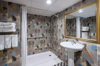 a bathroom with a sink and a mirror at Days Hotel by Wyndham North Bergen in North Bergen