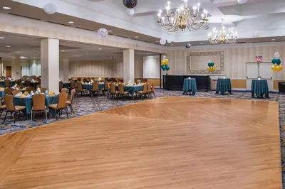 a ballroom with a dance floor and tables and chairs at Holiday Inn & Suites Pittsfield-Berkshires by IHG in Pittsfield