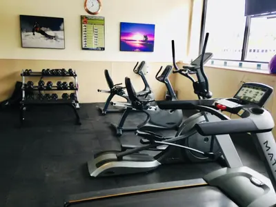 a gym with several cardio machines in a room at Holiday Inn & Suites Pittsfield-Berkshires by IHG in Pittsfield