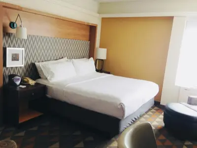 a hotel room with a large bed and a chair at Holiday Inn & Suites Pittsfield-Berkshires by IHG in Pittsfield