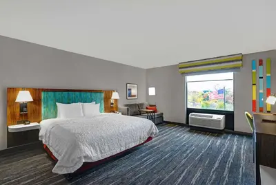 a hotel room with a bed and a window at Hampton Inn Utica in Utica