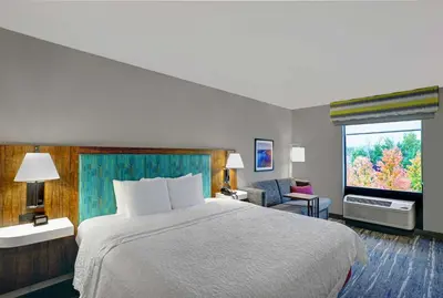 a hotel room with a bed and a window at Hampton Inn Utica in Utica