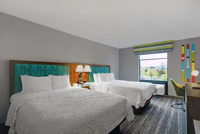 a hotel room with two beds and a window at Hampton Inn Utica in Utica