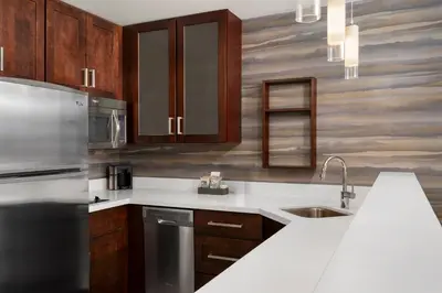 a kitchen with wooden cabinets and a stainless steel refrigerator at Residence Inn by Marriott Kingston in Kingston