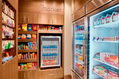 a grocery store aisle with a refrigerator full of food at Residence Inn by Marriott Kingston in Kingston