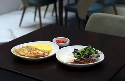 a table with two plates of breakfast food on it at DoubleTree by Hilton Hotel New York City - Chelsea in New York