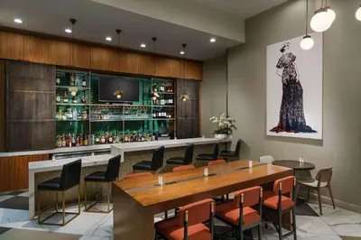 a bar in a restaurant with a long table and chairs at DoubleTree by Hilton Hotel New York City - Chelsea in New York