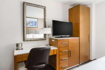 a room with a desk with a television and a chair at DoubleTree by Hilton Hotel New York City - Chelsea in New York