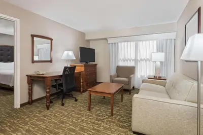 a hotel room with a couch and a desk at Homewood Suites by Hilton Holyoke-Springfield/North in Holyoke
