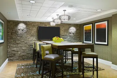 a dining room with a table and chairs and a tv at Hampton Inn Danbury in Danbury
