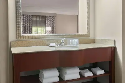 a bathroom with a sink with a mirror and towels at Hampton Inn Danbury in Danbury