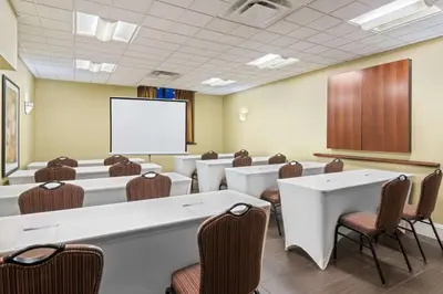 a conference room with tables and chairs and a screen at Hampton Inn Danbury in Danbury