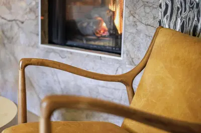 a chair sitting in front of a fireplace at Hotel Trilogy Albany Airport, Tapestry Collection by Hilton in Latham