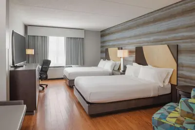 a hotel room with two beds and a desk at Hotel Trilogy Albany Airport, Tapestry Collection by Hilton in Latham