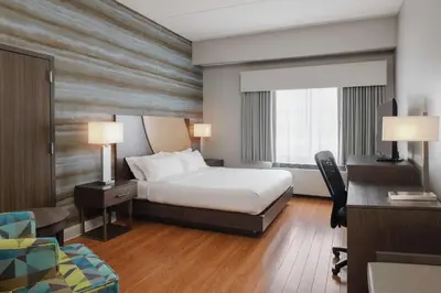 a hotel room with a bed and a desk at Hotel Trilogy Albany Airport, Tapestry Collection by Hilton in Latham
