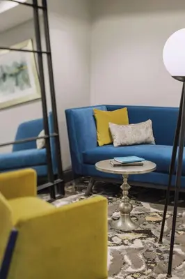 a living room with a blue couch and a table at Hotel Trilogy Albany Airport, Tapestry Collection by Hilton in Latham