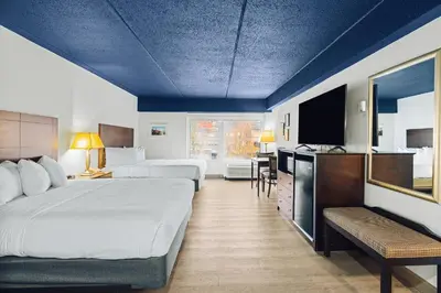 a hotel room with two beds and a flat screen tv at Hotel Downstreet, an Ascend Collection Hotel in North Adams