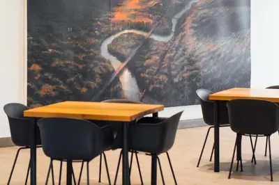 a group of tables and chairs in a room with a painting at Hotel Downstreet, an Ascend Collection Hotel in North Adams