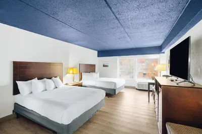 a hotel room with a bed and a tv and a bedroom at Hotel Downstreet, an Ascend Collection Hotel in North Adams