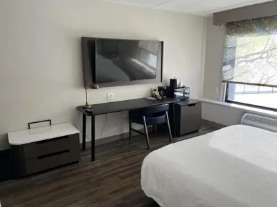 a hotel room with a desk with a bed and a television at Fairfield Inn & Suites Springfield Enfield in Springfield