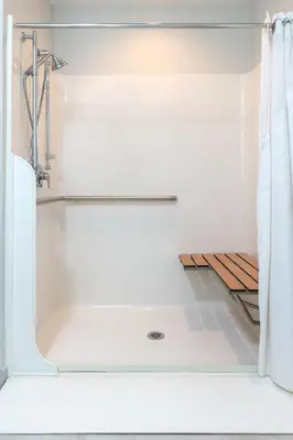 a white bath tub with a shower curtain in a bathroom at Holiday Inn Express Hotel & Suites Clifton Park by IHG in Clifton Park