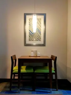a dining room table with two chairs and a mirror at Holiday Inn Express Hotel & Suites Clifton Park by IHG in Clifton Park