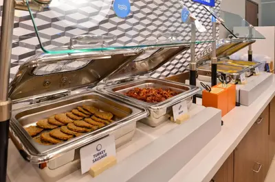 a buffet line with trays of food on a counter at Holiday Inn Express Hotel & Suites Clifton Park by IHG in Clifton Park