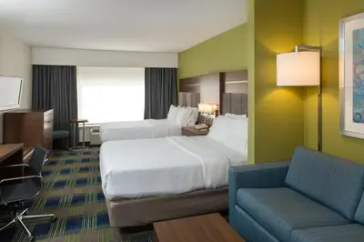 a hotel room with two beds and a couch at Holiday Inn Express Hotel & Suites Clifton Park by IHG in Clifton Park