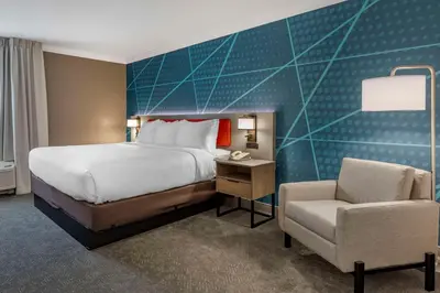 a hotel room with a bed and a chair at Comfort Inn & Suites Hadley - Amherst in Hadley