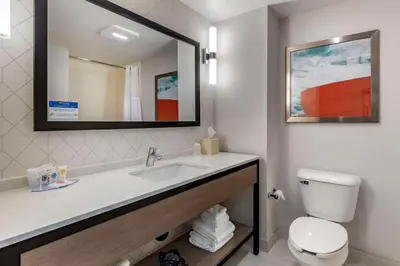 a bathroom with a sink and a toilet and a mirror at Comfort Inn & Suites Hadley - Amherst in Hadley