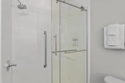 a shower with a glass door in a bathroom at Holiday Inn Express Hotel & Suites West Coxsackie by IHG in West Coxsackie
