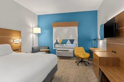 a hotel room with a bed and a desk and chair at Holiday Inn Express Hotel & Suites West Coxsackie by IHG in West Coxsackie