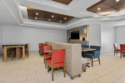 a dining room with tables and chairs and a table at Holiday Inn Express Hotel & Suites West Coxsackie by IHG in West Coxsackie