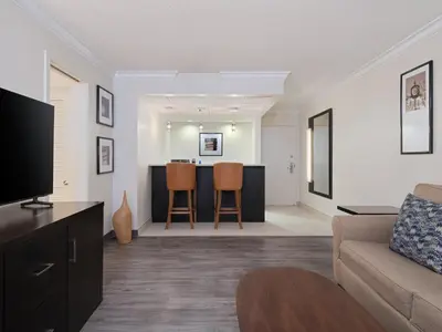 a living room with a couch and a bar at Crowne Plaza Suffern-Mahwah by IHG in Suffern