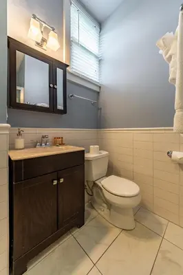 a bathroom with a toilet and a sink and a mirror at Homestead Inn in New Milford