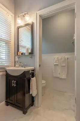a bathroom with a sink and a mirror and a toilet at Homestead Inn in New Milford