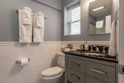 a bathroom with a toilet and a sink and a mirror at Homestead Inn in New Milford