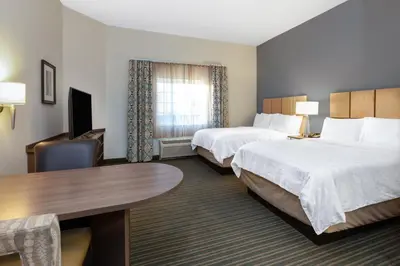 a hotel room with two beds and a desk at Candlewood Suites-West Springfield by IHG in West Springfield